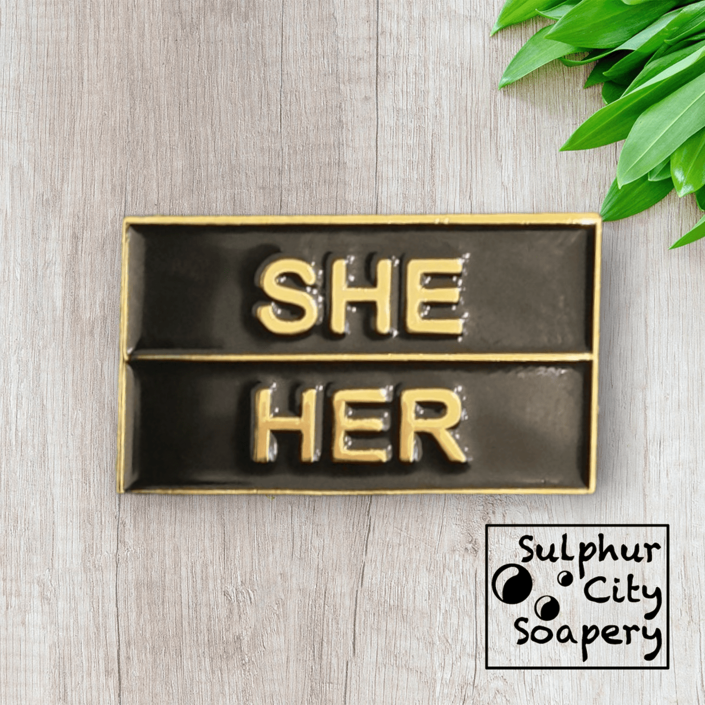 Sulphur City Soapery pronoun pin Pronoun pin in black and gold - She / Her